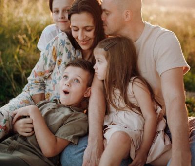 A joyful family enjoying quality time together on a sunset-lit meadow.